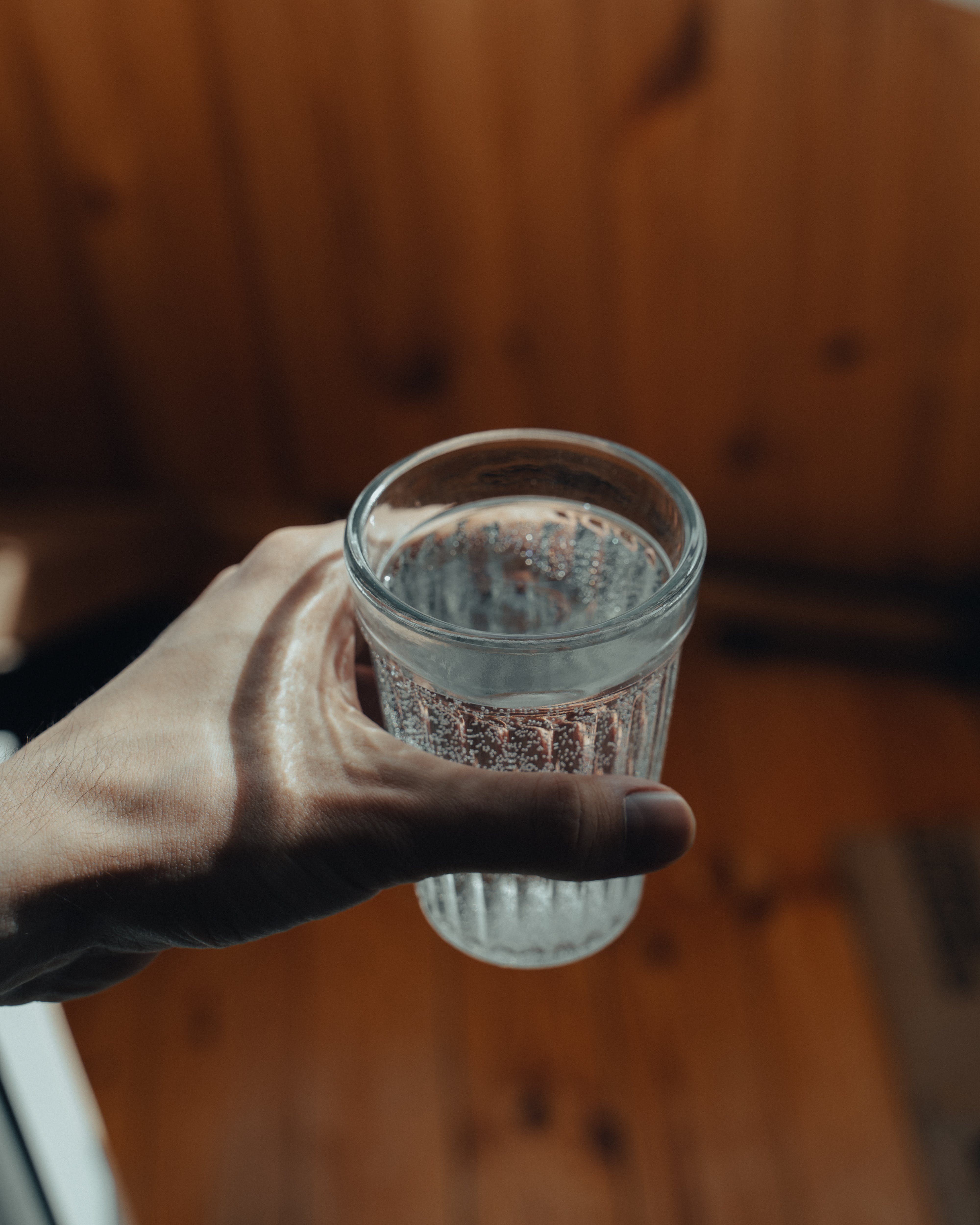 Crop person with faceted glass of water in hand